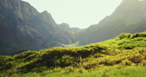 Majestic Mountains and Lush Greenery Under Bright Sunlight in a Tranquil Valley