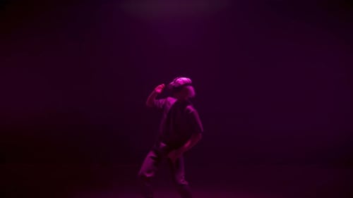 Man dances with a VR headset on a dark stage