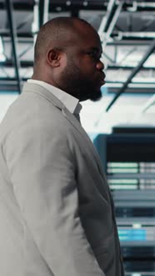 Vertical Video System Administrator Walking in Data Center with Rigs Doing Backups