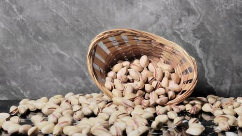Pistachios Overflowing from Basket on Marble Table