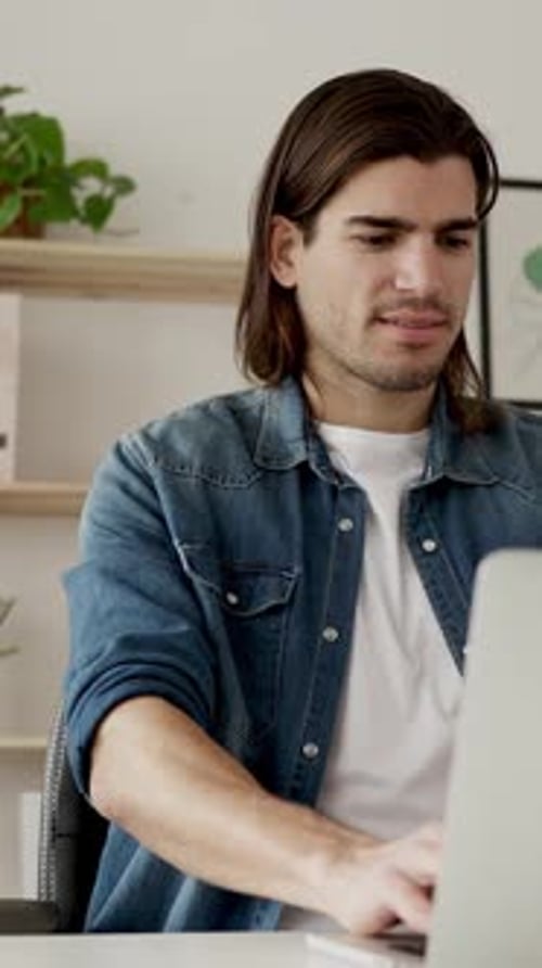 Man Works on Laptop Computer Indoors During Daytime