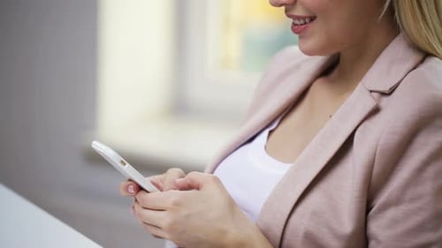 Smiling Woman Using Phone Indoors in Daytime