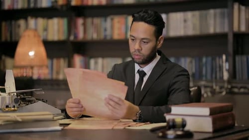 Man in Suit Reads Documents in Law Office