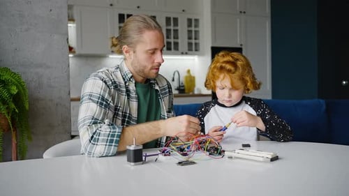 Son Helps Father Assemble Device Working with Screwdriver