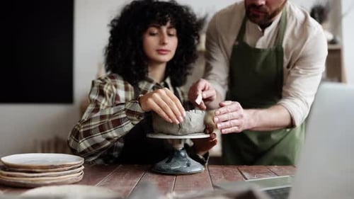 Woman Learning Pottery with Instructor in Studio