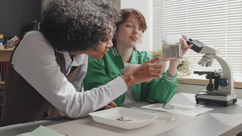 Students Observing Water Sample in Science Classroom