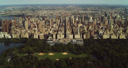 Central park and the majestic manhattan skyline shimmer under blue New York skies
