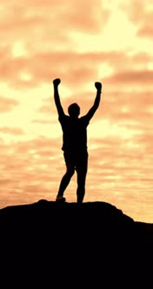 Man Silhouette with Arms Raised on Hill at Sunrise