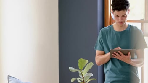 Young Adult Using Tablet in a Bright Home