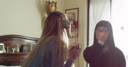 Young Women Friends Dancing and Listening to Music