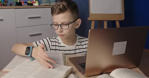 Boy Studying with Laptop and Books Indoors