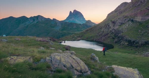 Midi d Ossau peak, lake reflection and photographer taking photos in Spanish pyrenees Anayet lakes.