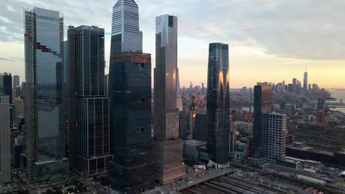 Aerial view of tall high rise in Hudson Yards, colorful sunset in New York - pan, drone shot