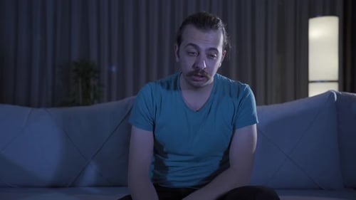 Mann mit Schlafproblemen, der nachts zu Hause steht.
