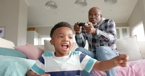 Boy and Grandfather Playing Video Games at Home
