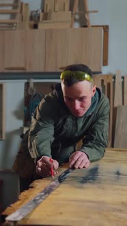 Carpenter Male Worker in a Repair Shop Draws a Line on a Wooden Board A Carpenter Works in a