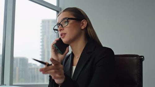 Woman Executive Talking Smartphone in Office Closeup