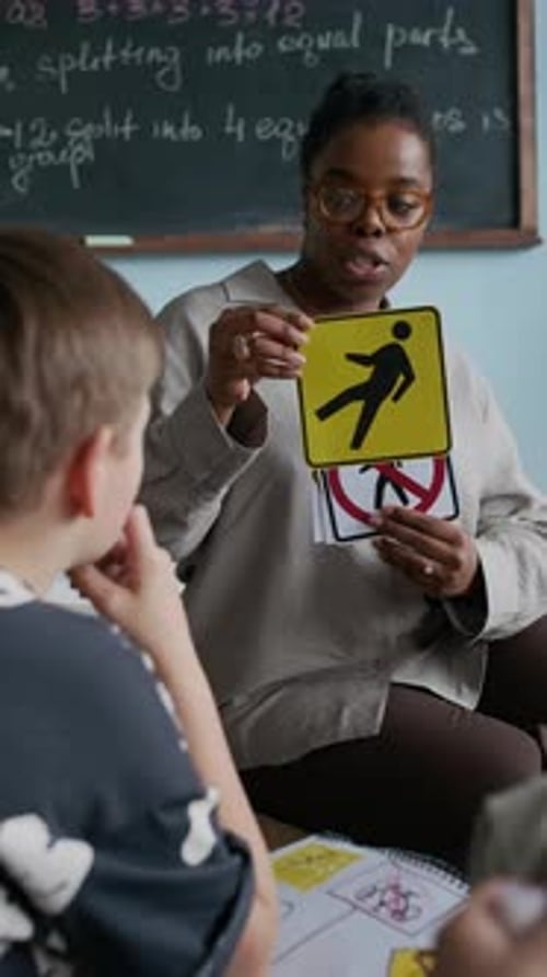 Teacher Explaining Road Safety Rules and Showing Traffic Signs