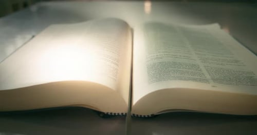 Leuchtende Seiten eines aufgeschlagenen Buches, Nahaufnahme, Zeitlupe