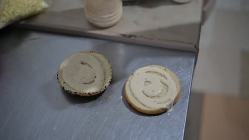 Burger Buns Being Dressed with Sauces