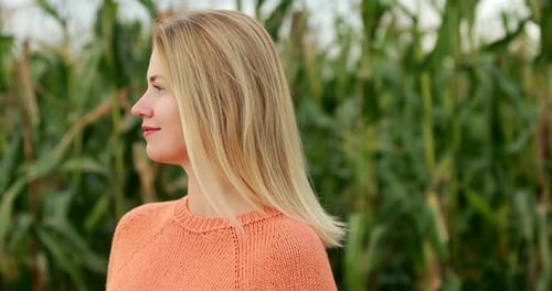 Woman Smiling in a Cornfield on a Sunny Day