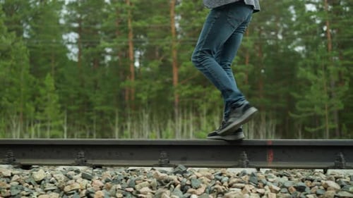 Man Walking on Rural Railroad Track in Nature