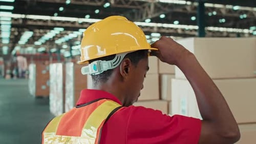 Porträt eines jungen männlichen Arbeiters gemischter Abstammung mit Helm