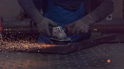 Close Up of Hands of a Metal Fabricator Wearing Safety Gloves and Grinding a Steel Tube Sculpture