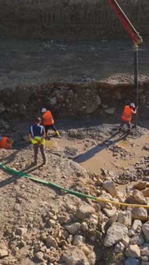 Vídeo vertical: trabajadores utilizan máquinas para construir en una gran obra