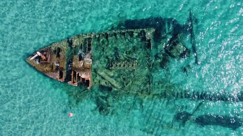 Altes rostiges Schiffswrack im türkisfarbenen Meer von oben