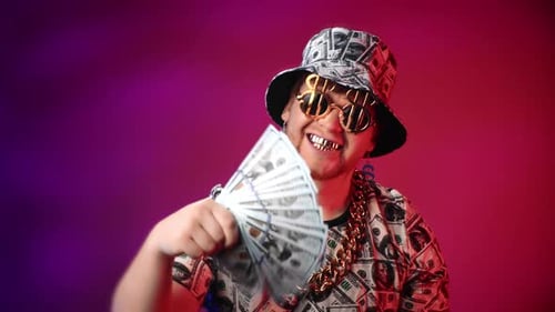 Crazy Rap Star with Dollars and Golden Accessories Looking at Camera in Studio Golden Teeth Smile