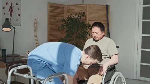 Physiotherapist Caring About Patient during His Rehab