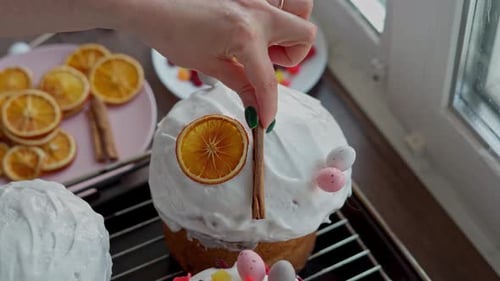 Close-up of a Caucasian Woman's Hand decoretes freshly cooked Easter Cakes
