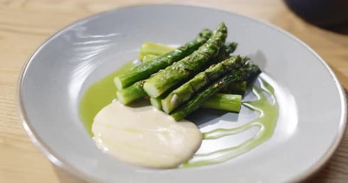 Grilled Asparagus Served in Restaurant on a Plate with Sause Healthy Food Eating with Fork and Knife