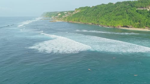 Luftaufnahme von Surfern, die auf Bali auf Meereswellen reiten