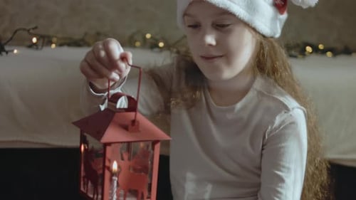 A Cute Little Girl Wearing Santa's Hat is Holding a Lantern with Burning Candle The Concept of Hope