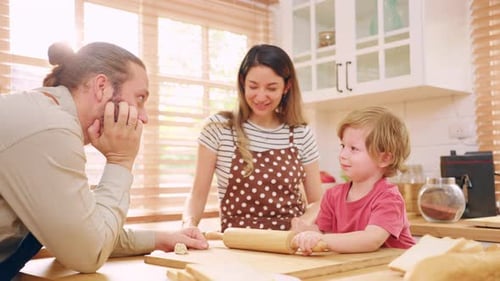 Caucasian attractive couple baking bakery with son in kitchen at home.