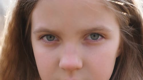 Close Up Upset Female Face of Little Kid Looking Into Camera with a Disappointing Sight Facial