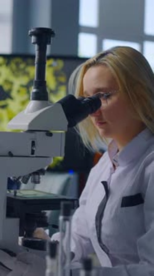 Female Scientist Using Microscope for Scientific Research in Lab