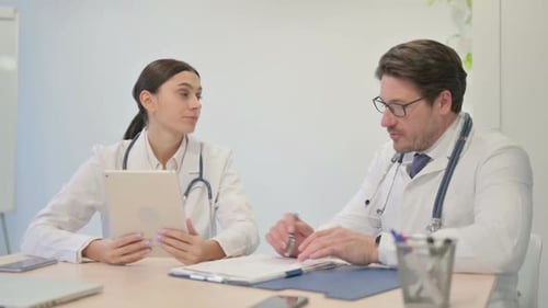 Doctors Consulting and Taking Notes in Bright Office