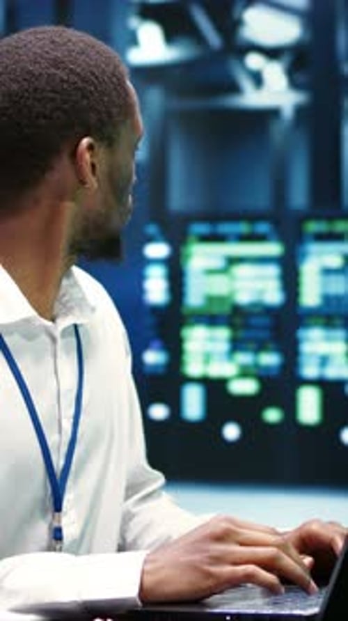 Young Adult Typing on Laptop in Tech Office