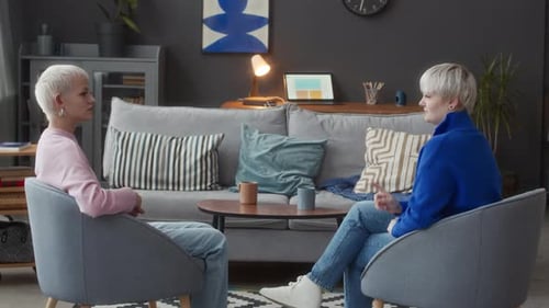 Two Young Adults Chatting in Living Room