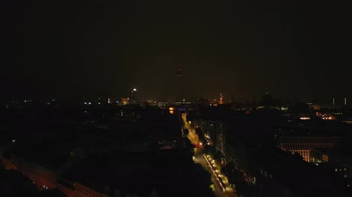 Aerial View of Night City at Storm Tall Fernsehturm TV Tower Silhouette Appearing Against Lightning