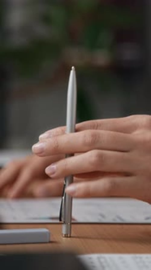 Office Worker Tapping Pen on Desk While Managing Documents