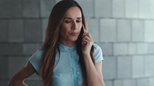 Smiling businesswoman talking on smartphone in the city street outdoors in slow motion