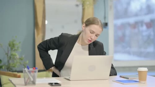 Young Woman with Back Pain in Office