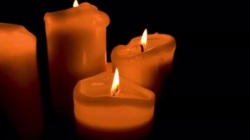 Groupe de quatre bougies, composition de feu orange sur fond noir, Ralenti