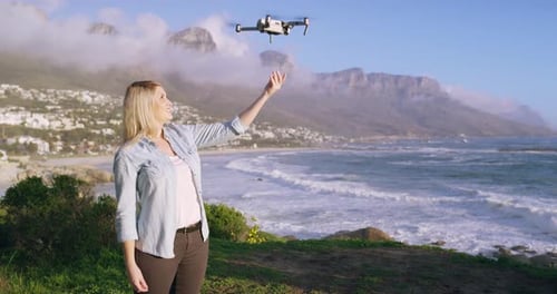 4k-Videoaufnahmen eines jungen Mannes, der eine Drohne am Strand fliegt