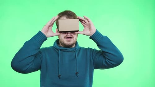 Man Wearing Cardboard VR Headset Experiencing Virtual Reality
