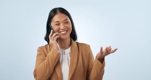 Happy asian woman, phone call and laughing for funny joke or conversation against a studio